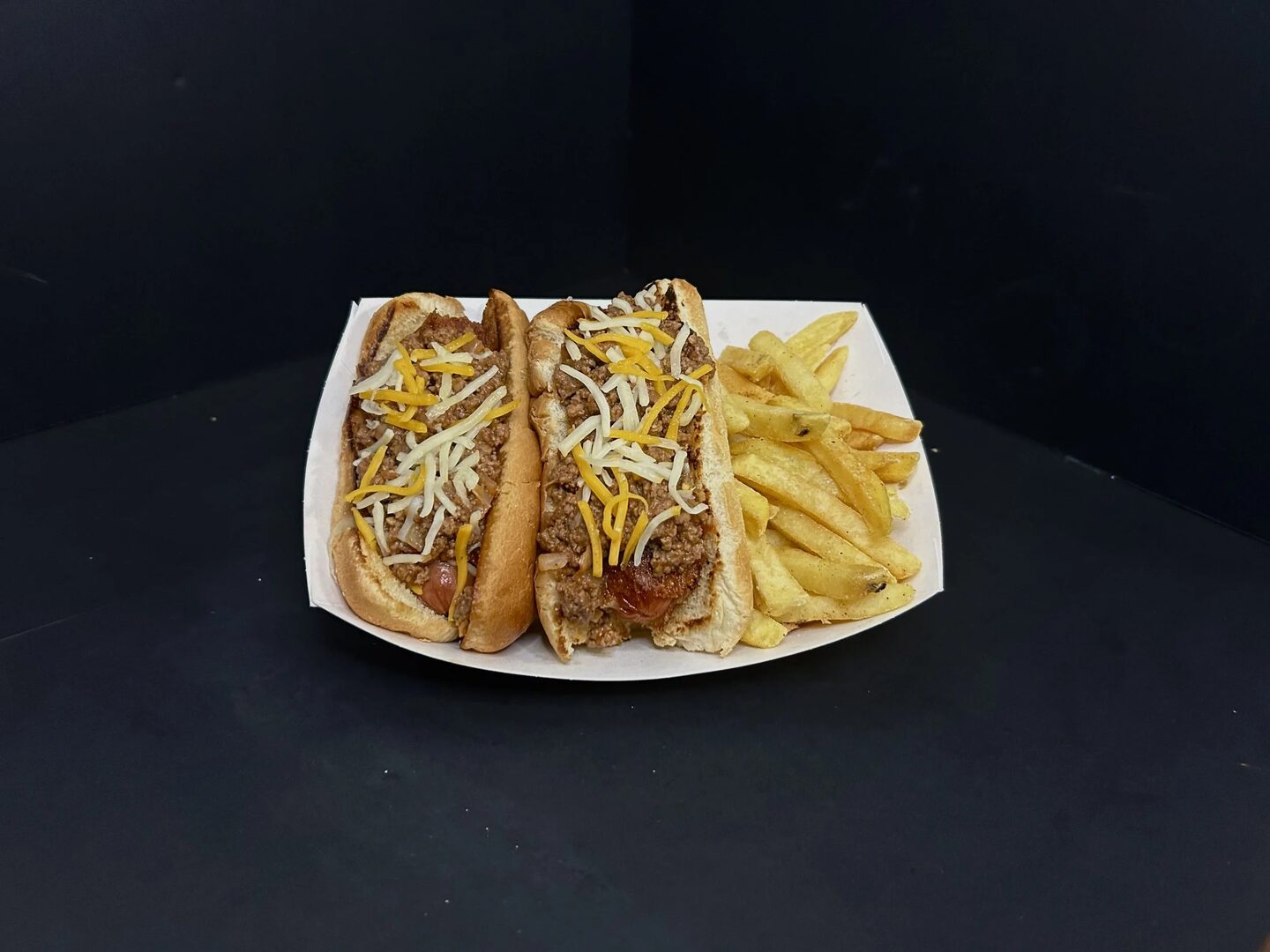 Two Big A's hot dogs topped with ground beef and shredded cheese, served with fries.